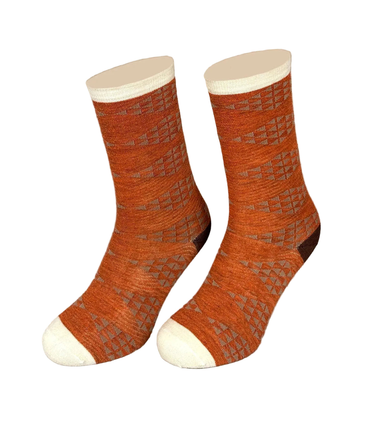 A pair of crew socks with a textured geometric pattern in rust orange and gray, featuring solid cream cuffs, toes, and heels, displayed on a neutral beige background.